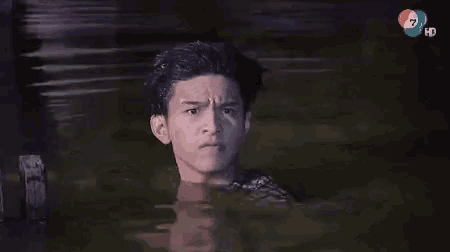a man is standing in a body of water with the number 7 on the bottom right