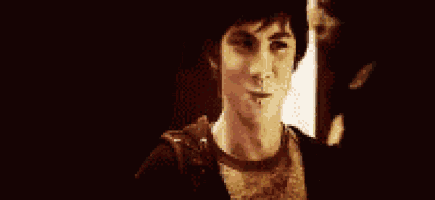a young man is smiling in a dark room in a blurry photo .