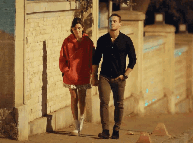 a man and a woman are walking down a street