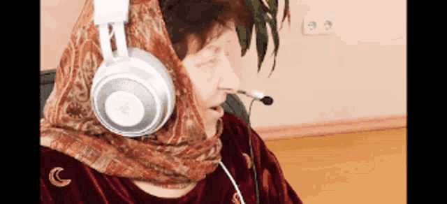 a woman wearing a scarf and headphones with a microphone on her mouth