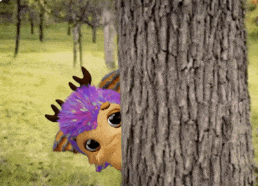 a stuffed animal with purple hair and antlers peeking out from behind a tree