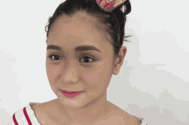 a young girl wearing a headband with a heart on it looks at the camera .