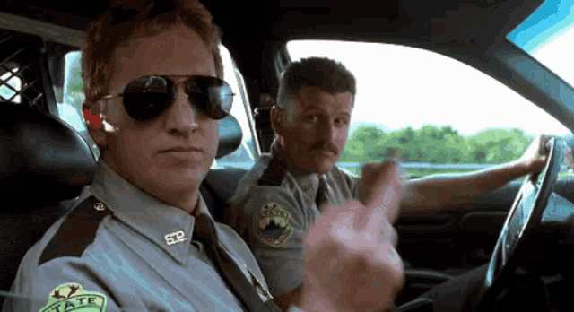 two police officers in a car with one wearing a badge that says sdp