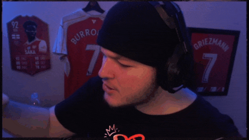 a man wearing headphones and a black hat with the name burroughs on his shirt