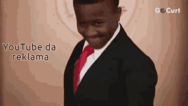 a man in a suit and tie is standing in front of a sign that says youtube da reklama