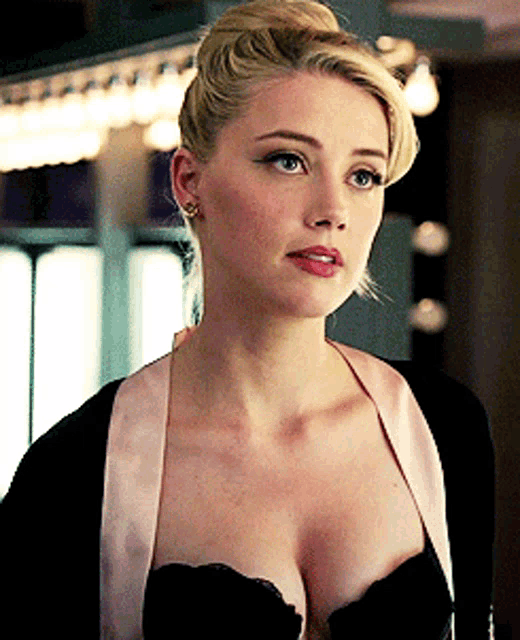 a woman with a very large breast is wearing a black bra and a pink jacket