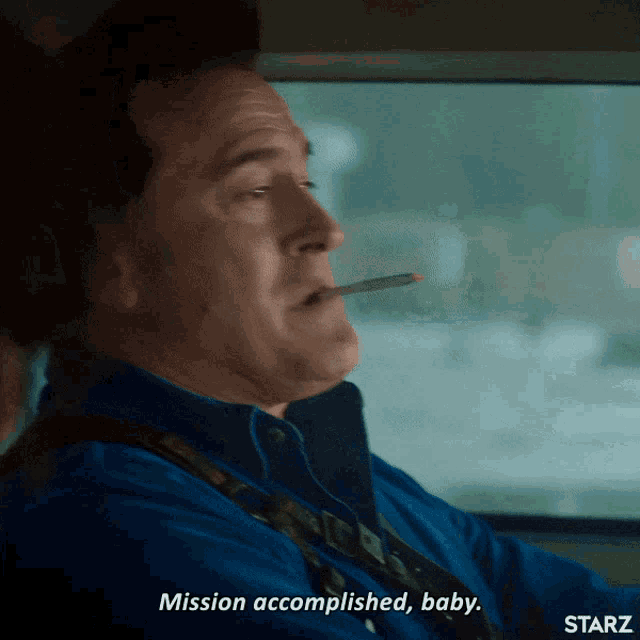 a man smoking a cigarette in a car and saying mission accomplished baby