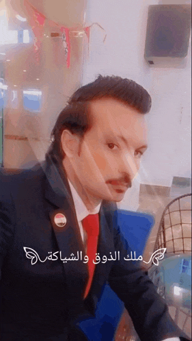 a man in a suit and tie has arabic writing on the bottom