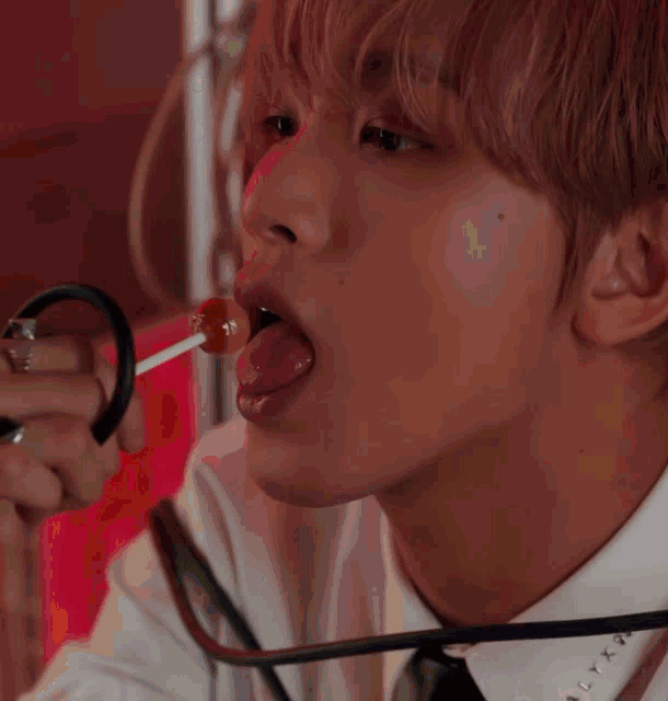 a man wearing a white shirt and black tie has a sticker on his collar that says ' nct dream '