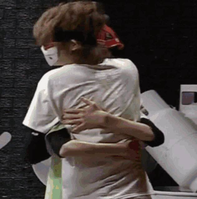 a man and a woman are hugging each other in a dark room .