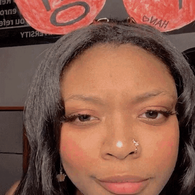 a close up of a woman 's face with a sign behind her that says yt12h
