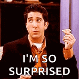 a man in a suit and tie is holding a piece of pizza and saying `` i 'm so surprised `` .