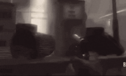 a blurred image of a person holding a gun in a foggy area .