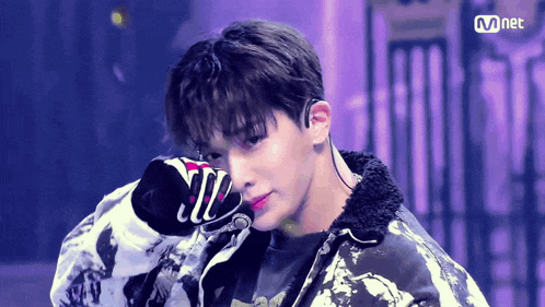 a close up of a person 's face with the word mnet on the bottom right