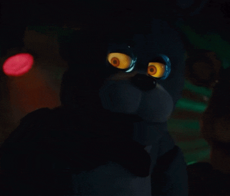 a close up of a teddy bear with glowing eyes in the dark