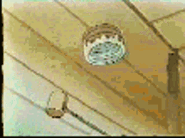 a clock is hanging from the ceiling in a room .