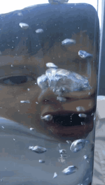 a close up of a person 's face in a glass