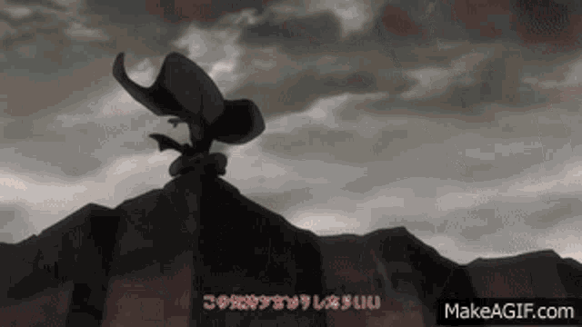 a black and white image of a person standing on top of a mountain .