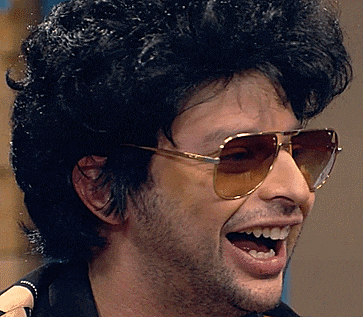 a man wearing sunglasses and a wig is smiling