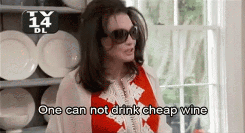 a woman wearing sunglasses and a red top says one can not drink cheap wine .