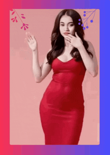 a woman in a red dress is waving her hand and covering her mouth .