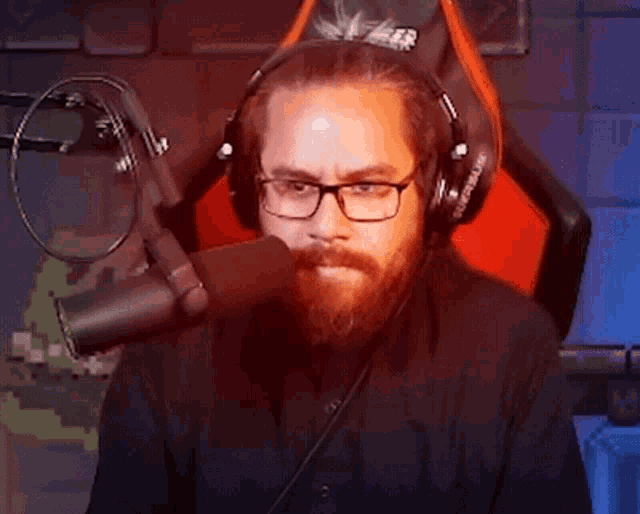 a man with a beard and glasses is wearing headphones and a microphone