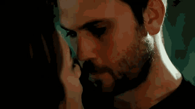a man and a woman are kissing each other in a dark room .