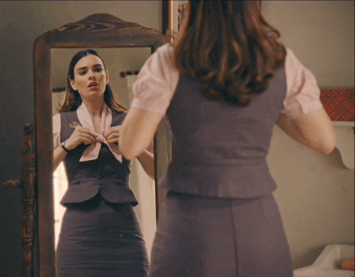 a woman is looking at herself in the mirror