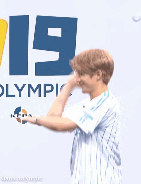 a man standing in front of a sign that says olympic