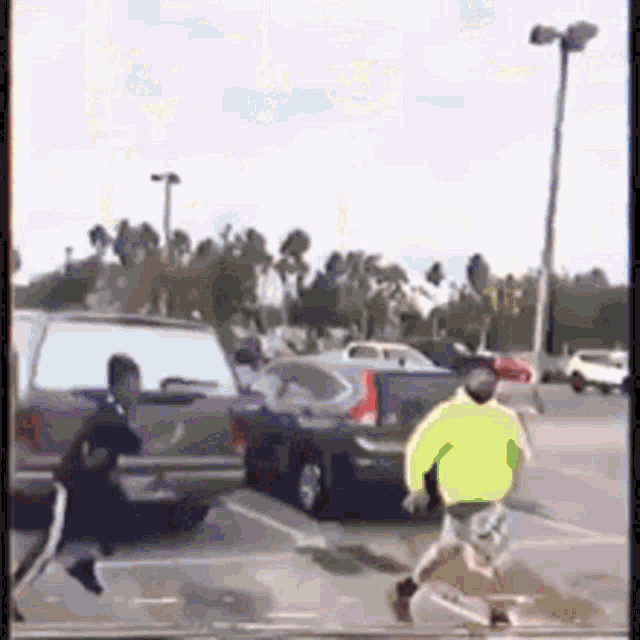 a man in a neon green sweater is running in a parking lot