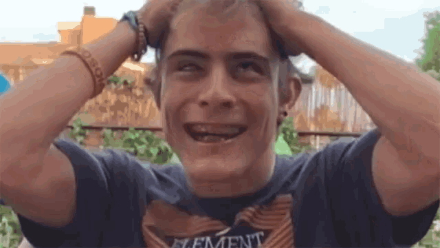 a young man with braces on his teeth is wearing a shirt with the word element on it