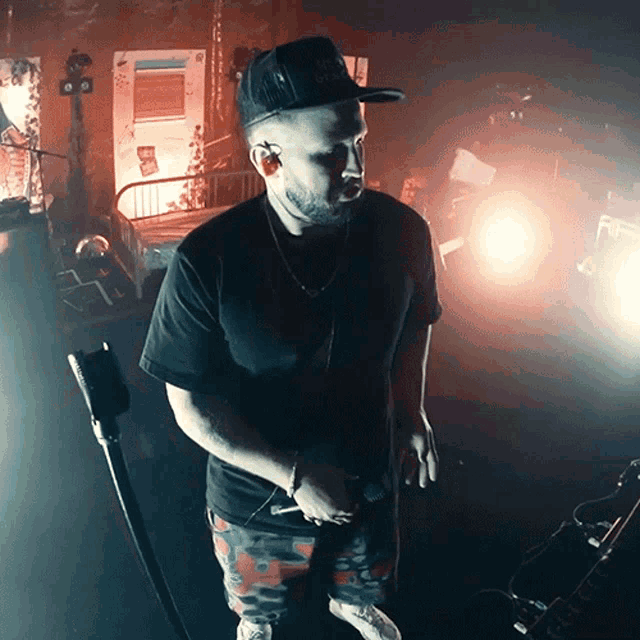 a man singing into a microphone wearing a hat that says ' adidas '
