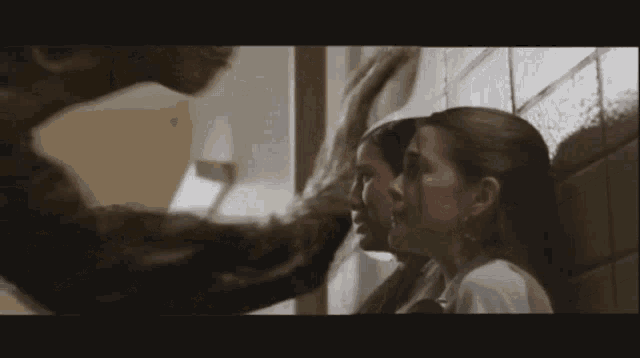 a group of women are standing in a hallway looking at a monster ..