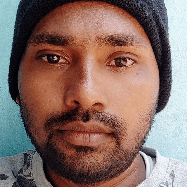 a man with a beard wearing a beanie looks at the camera