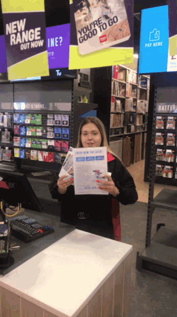 a woman in a store holding a flyer that says you 're good to go