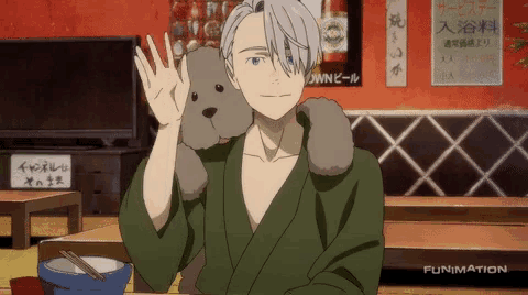 a man in a kimono is sitting at a table with a stuffed dog on his shoulder .
