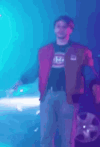 a man is standing on a stage with his arms outstretched in a club .