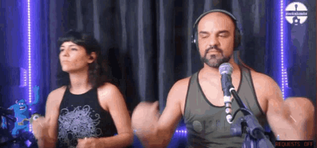 a man and a woman are dancing in front of a microphone with requests off displayed