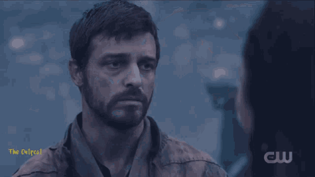 a woman with her eyes closed looks at a man with the caption " the outpost "