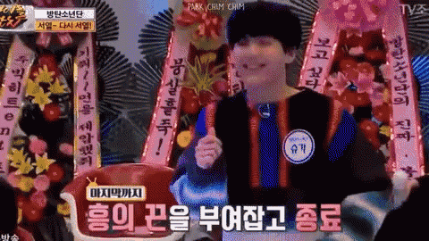 a tv screen shows a man holding a stick in front of a bunch of flowers and ribbons