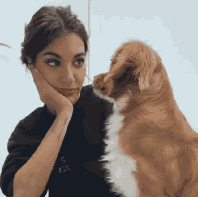 a woman with a tattoo on her arm that says " i love you " looks at a dog