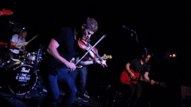 a man is playing a violin in front of a pearl drum