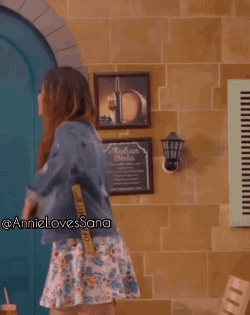 a woman dancing in front of a wall with a sign that says italian soda