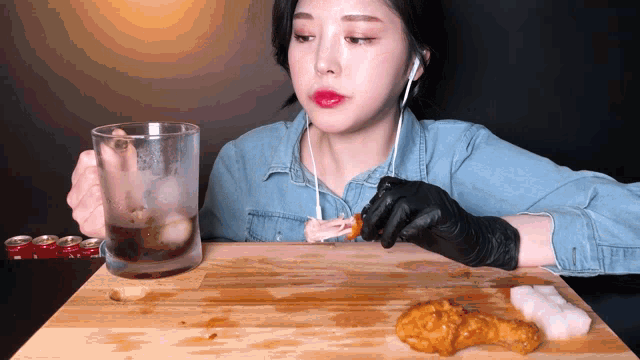 a woman is eating chicken and drinking soda