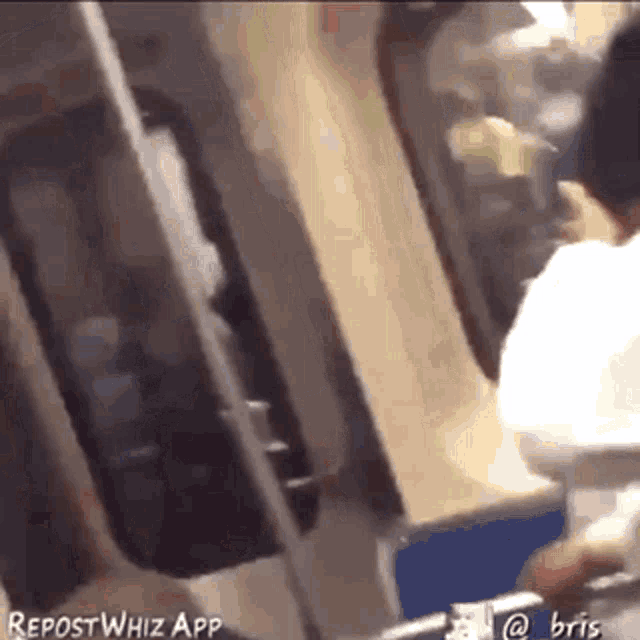 a man is talking on a cell phone while sitting on a train .