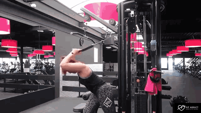 a woman is using a machine in a gym that says big addict on the bottom