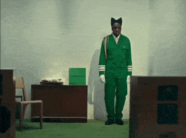 a man in a green uniform stands in a room