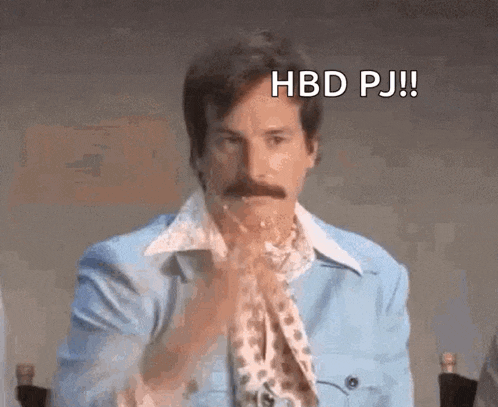 a man with a mustache is wearing a blue jacket and eating a piece of cake .