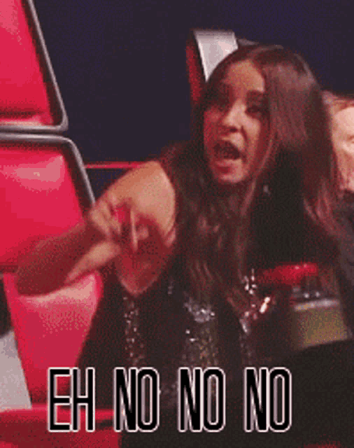 a woman sitting in a red chair with the words " eh no no no " on the bottom