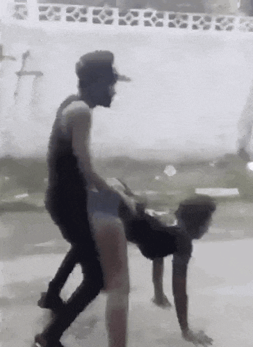 a man is riding a woman on his back on the ground .
